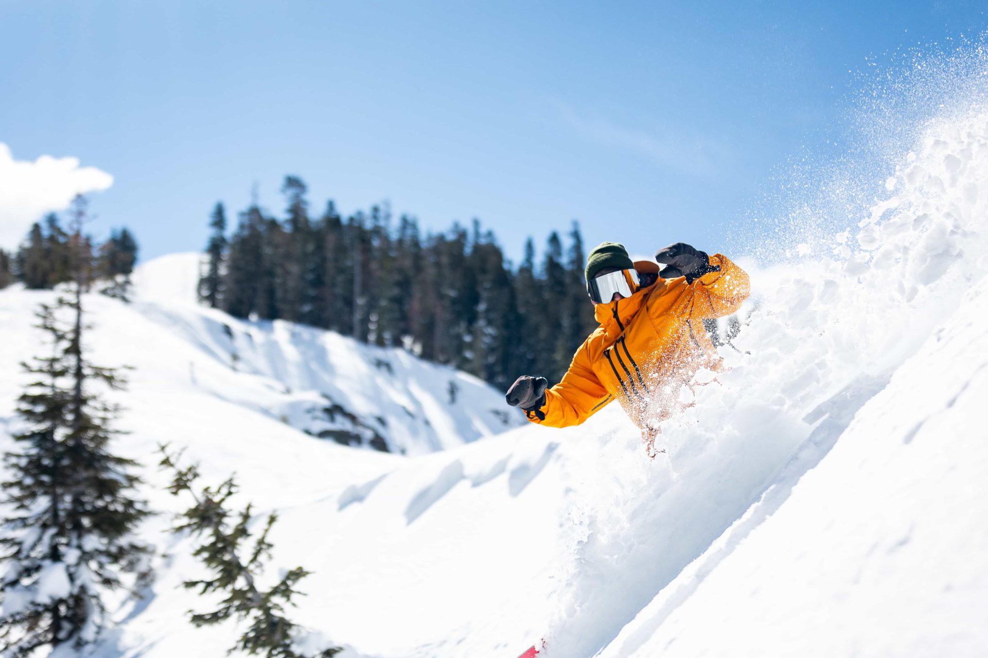 Un snowboarder sillonne la neige poudreuse profonde à l'aide du Cali Pass.