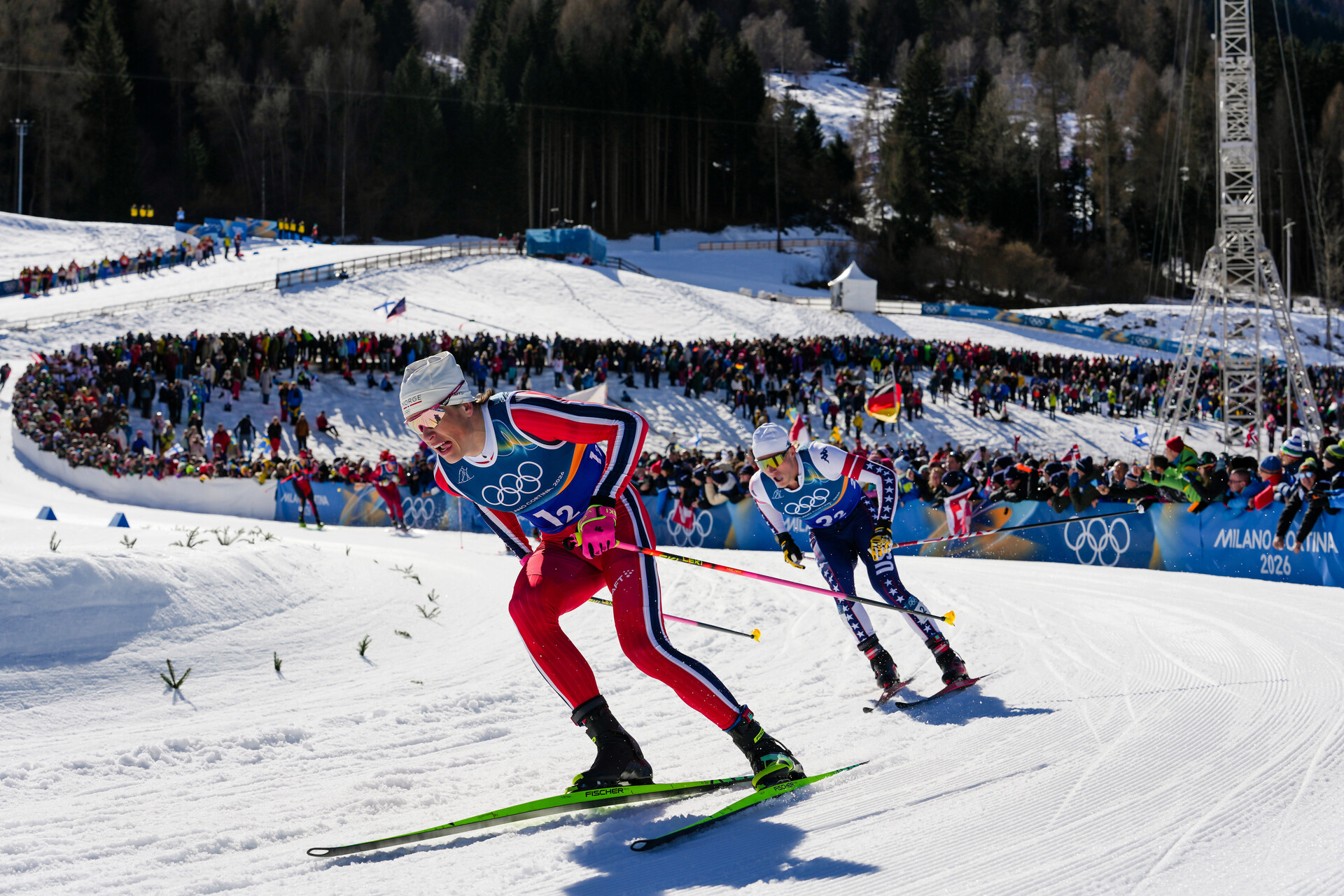 Le Norvégien Johannes Hoesflot Klaebo et l'Américain Gus Schumacher, à droite, participent au sprint libre par équipe masculine de ski de fond aux Jeux olympiques d'hiver de 2026.
