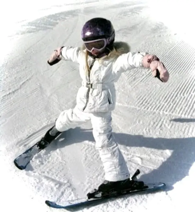 enfant dans des vêtements de ski de haute qualité qui reste au chaud sur les pistes