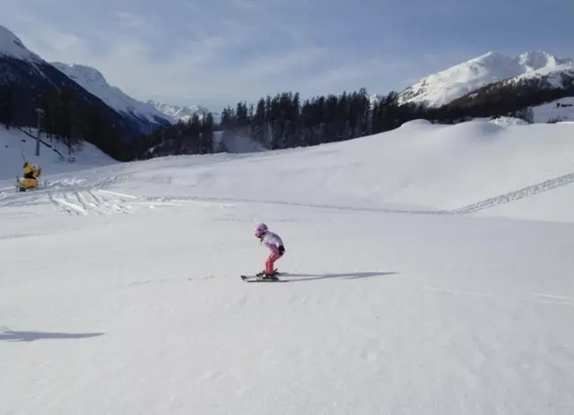 conseils ski avec enfants - jeune skieur débutant apprenant sans bâtons sur une pente douce