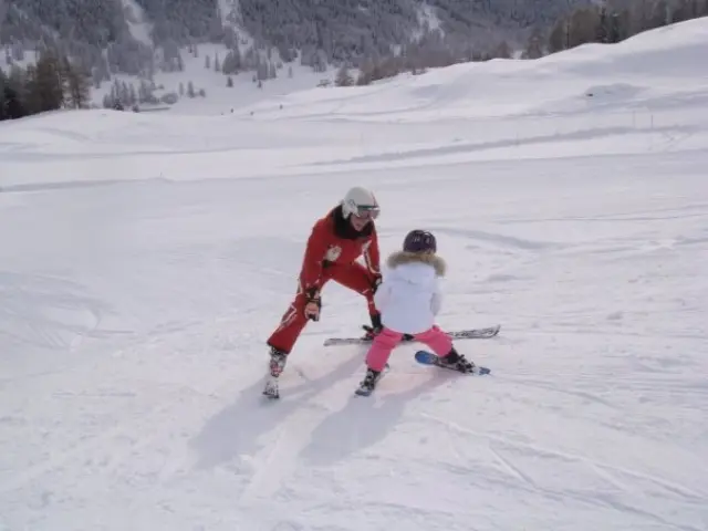 conseils ski avec enfants - jeune skieur débutant apprenant sans bâtons sur une pente douce