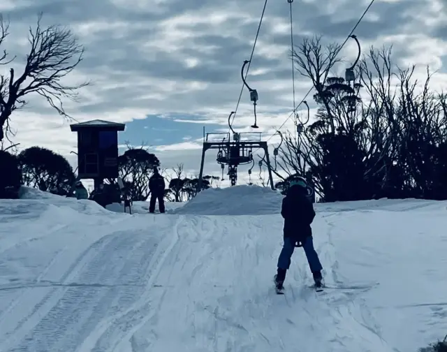 enfant maîtrisant un téléski à barre en T de manière indépendante dans une station de ski