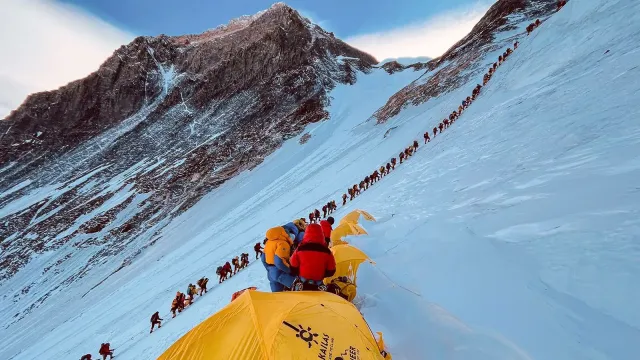 Cette photographie de 2021 montre des alpinistes alignés alors qu'ils gravissent une pente lors de leur ascension vers le sommet du mont Everest. Crédit photo : CNN