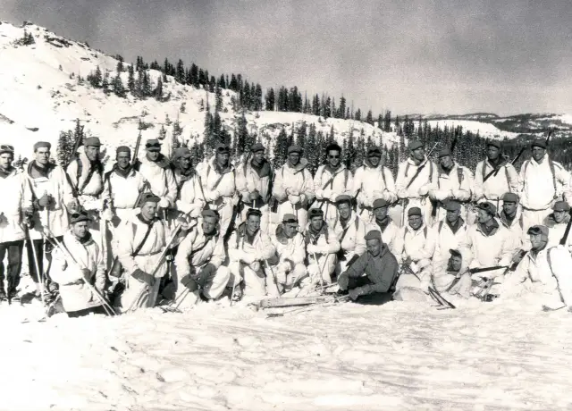 Skieurs militaires en blanc sur une montagne enneigée