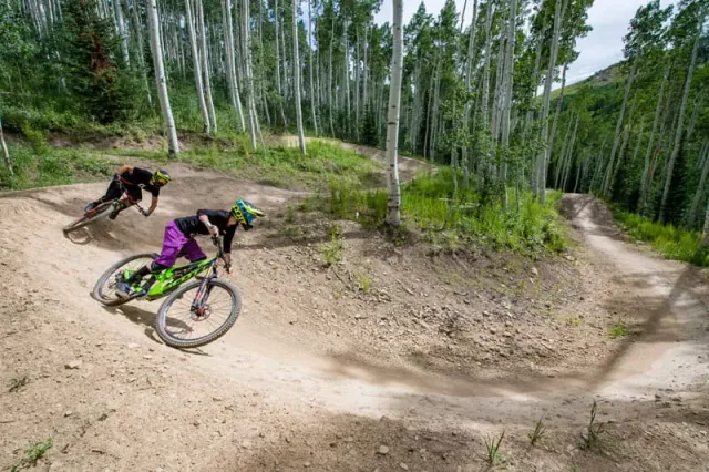 Vététiste empruntant un sentier fluide construit mécaniquement au parc de vélos de descente de Deer Valley, desservi par trois télésièges