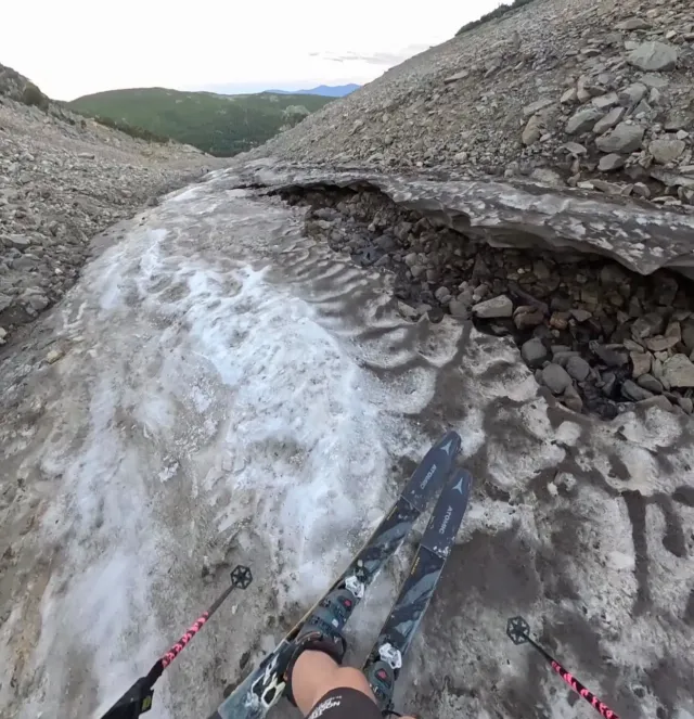 Un skieur dévalant le tout petit morceau de neige très sale du glacier St. Mary's 