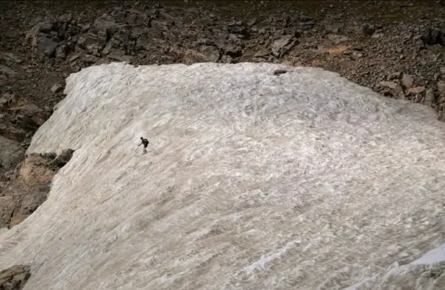 Un skieur effectuant des virages estivaux sur le glacier St. Mary's 